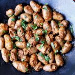 Chicken hearts are served on a dark plate.