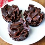 Coconut clusters are served on a white plate with a napkin.