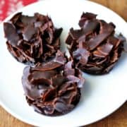 Coconut clusters are served on a white plate with a napkin.