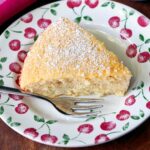 Keto coconut cake is served on a plate with a fork.