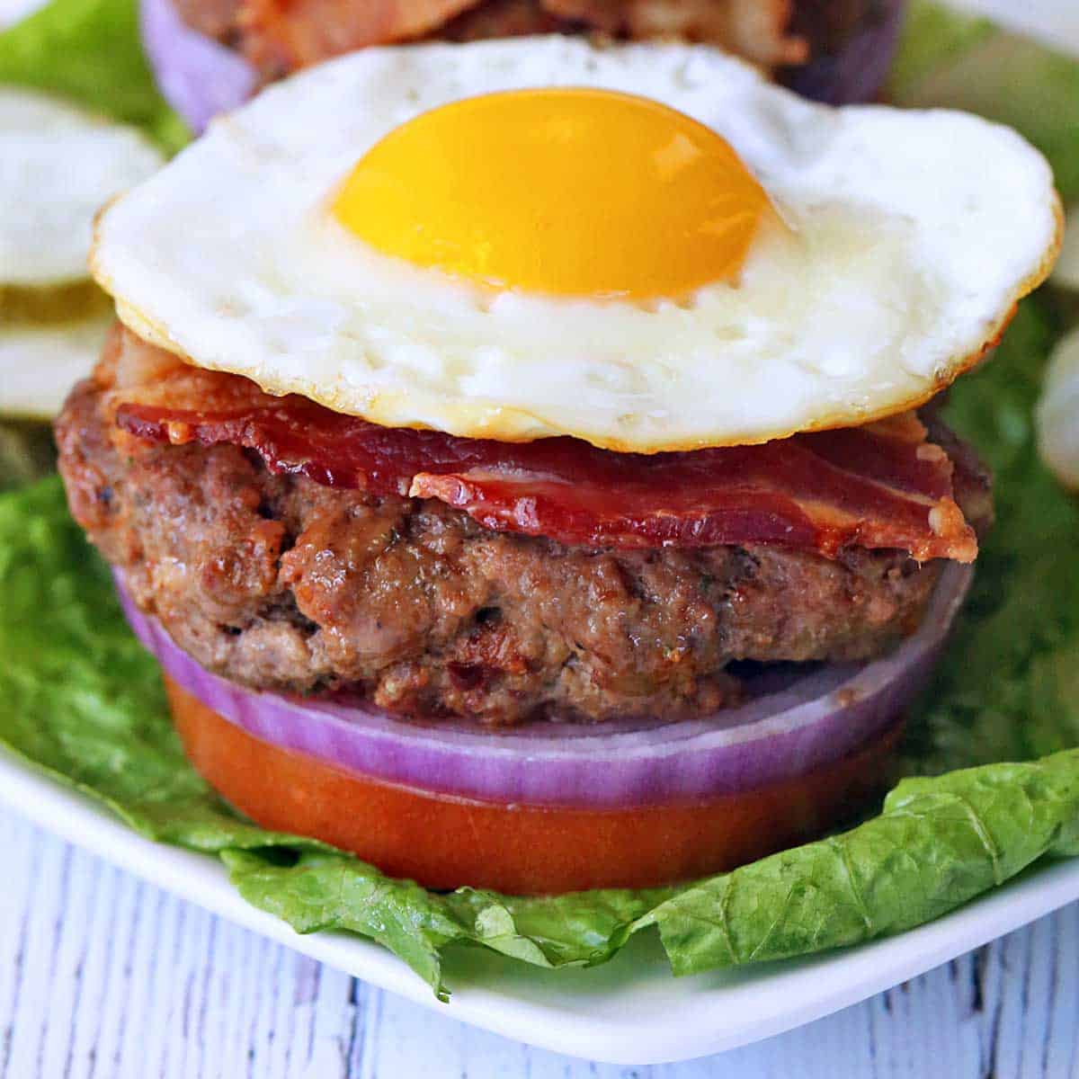 Bacon burger is topped with a fried egg.