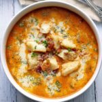 Keto fish chowder is served in a white bowl with spoons.