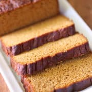 Keto pumpkin bread, sliced, is served on a white tray.
