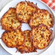Keto cheese chips are arranged on a white plate.