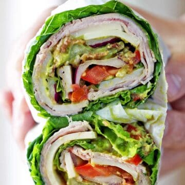 Lettuce sandwich os held in a person's hand.