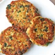 Salmon cakes are served on a white plate.