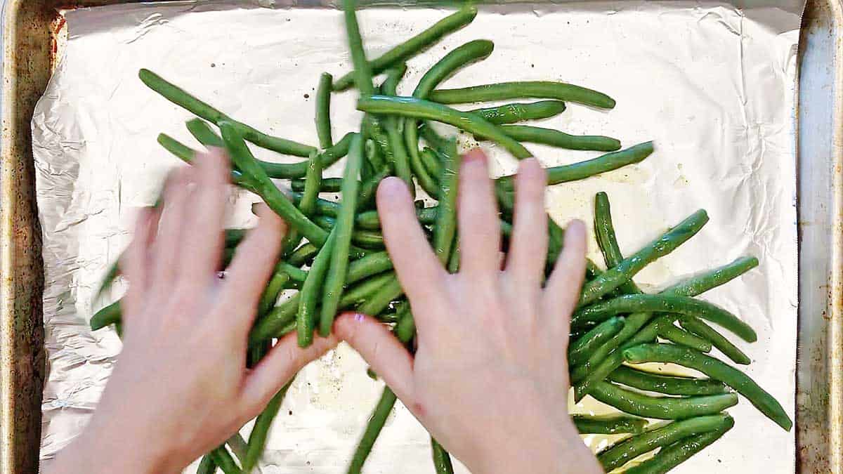 Using hands to coat the beans.