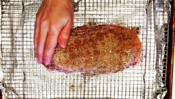 Rubbing the pork with spices.