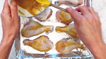 Coating the chicken in the sauce.