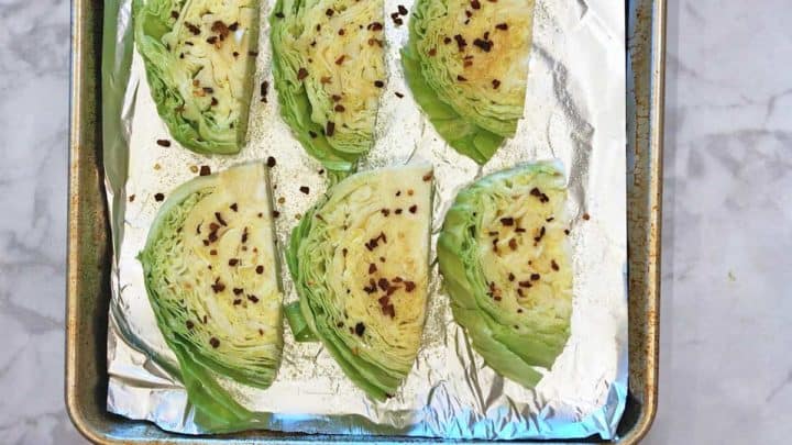 Seasoned cabbage on a baking sheet.