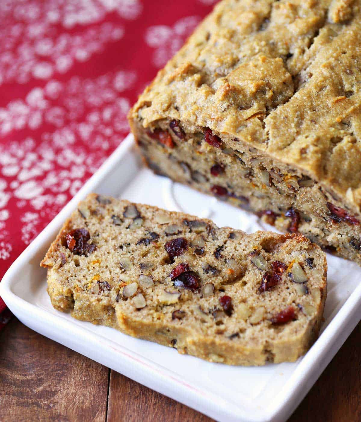 A keto fruit cake is sliced and served on a white tray. 