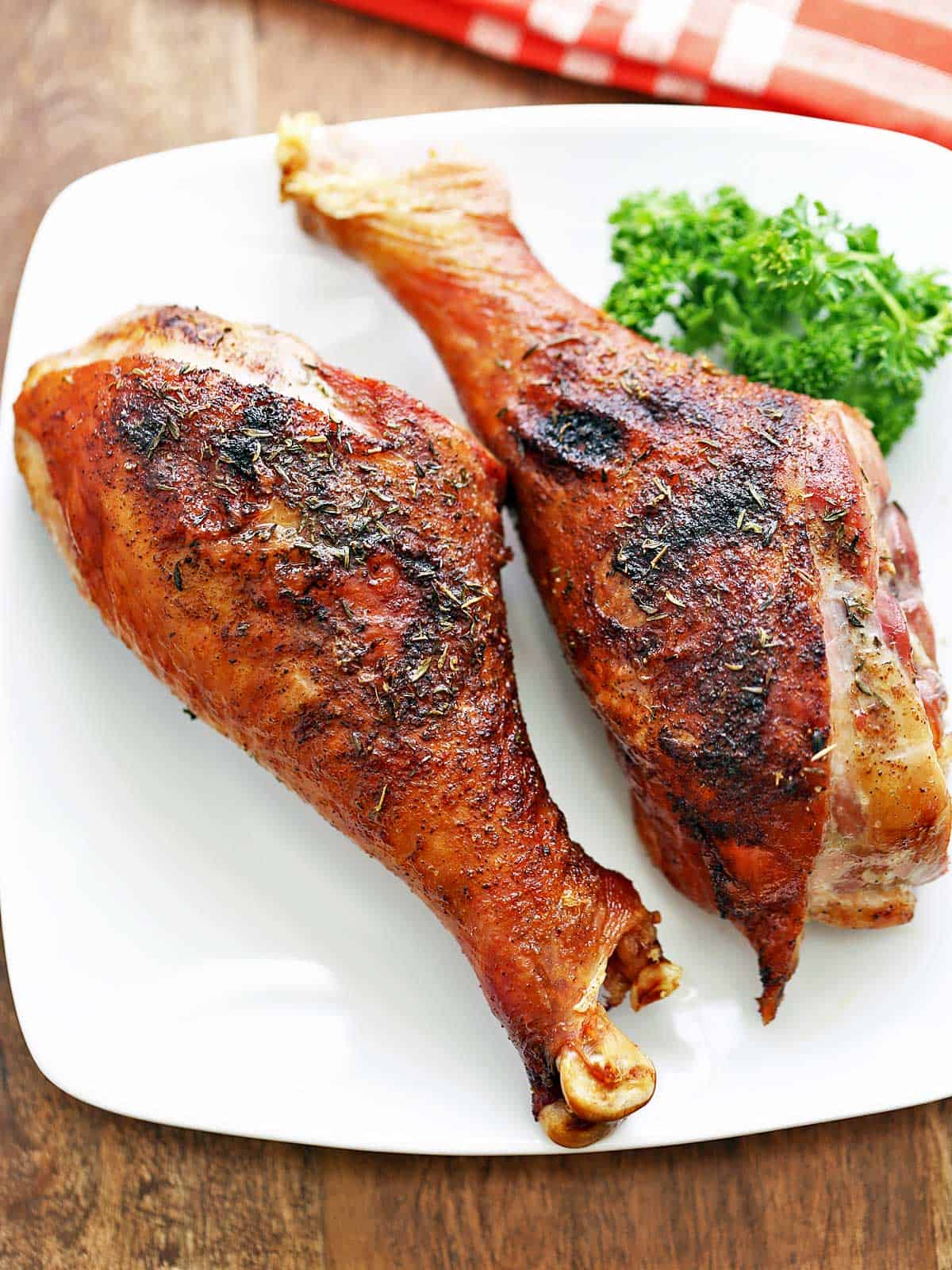 Two turkey legs are served on a white plate.