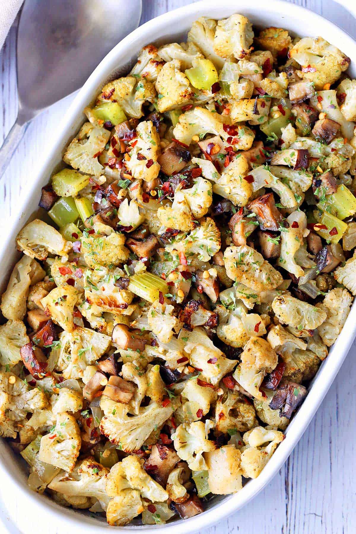 Cauliflower stuffing is served in a white baking dish. 