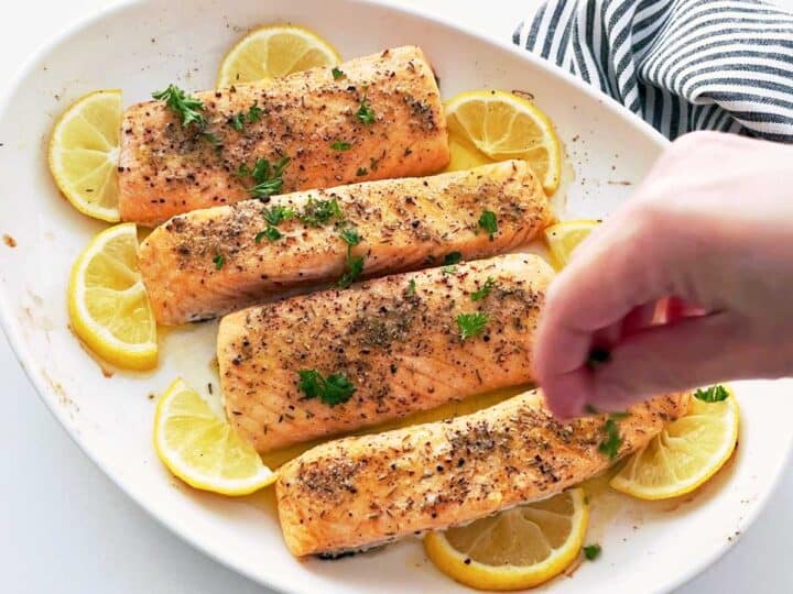Garnishing the salmon with parsley.