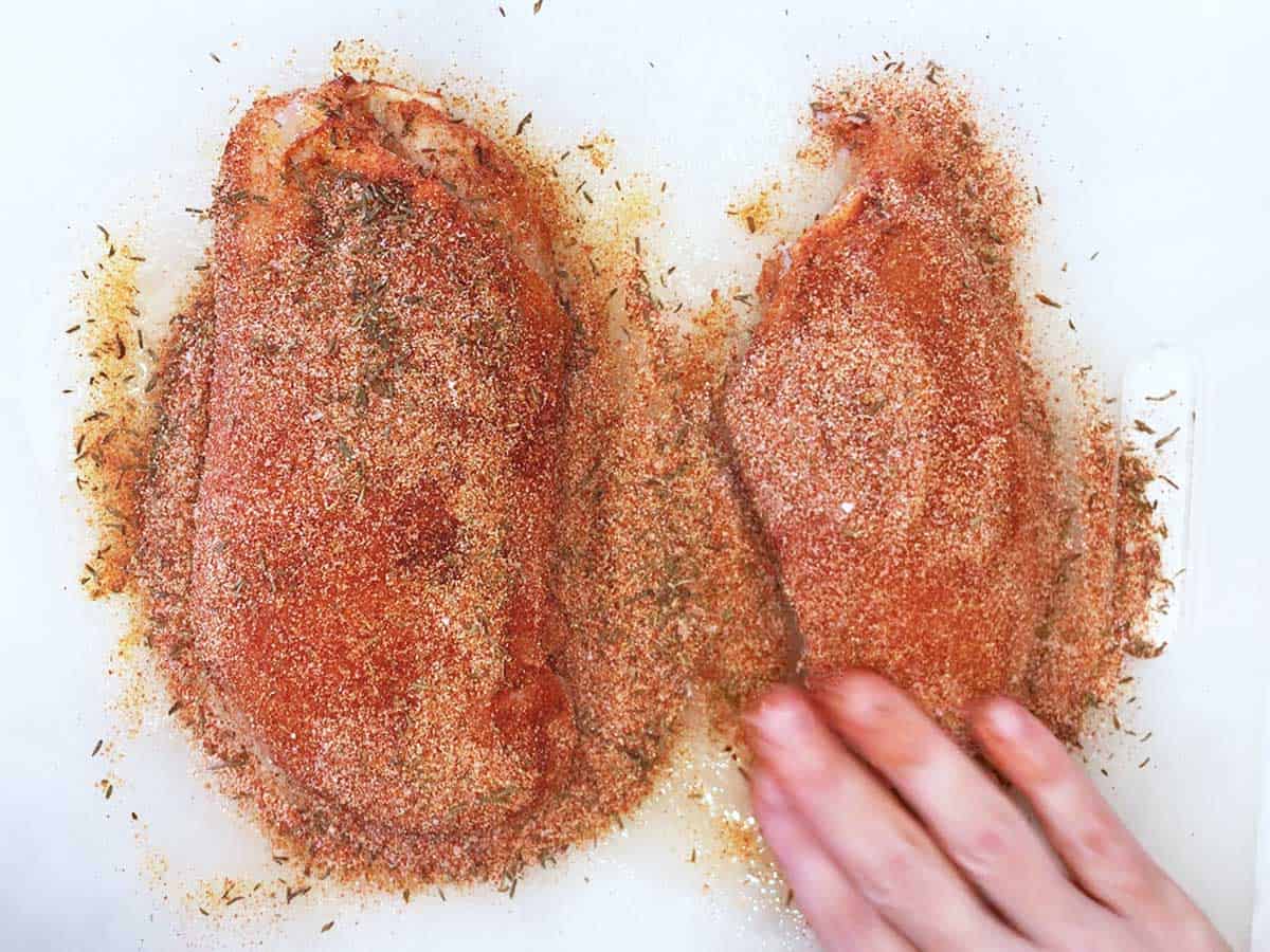 Coating chicken with spices.
