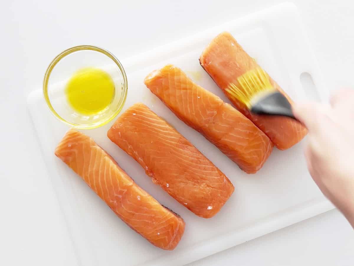 Coating salmon fillets with olive oil.