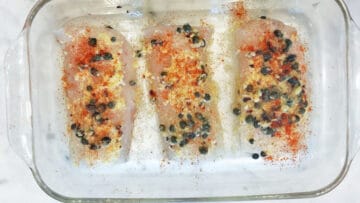 Seasoning the cod.