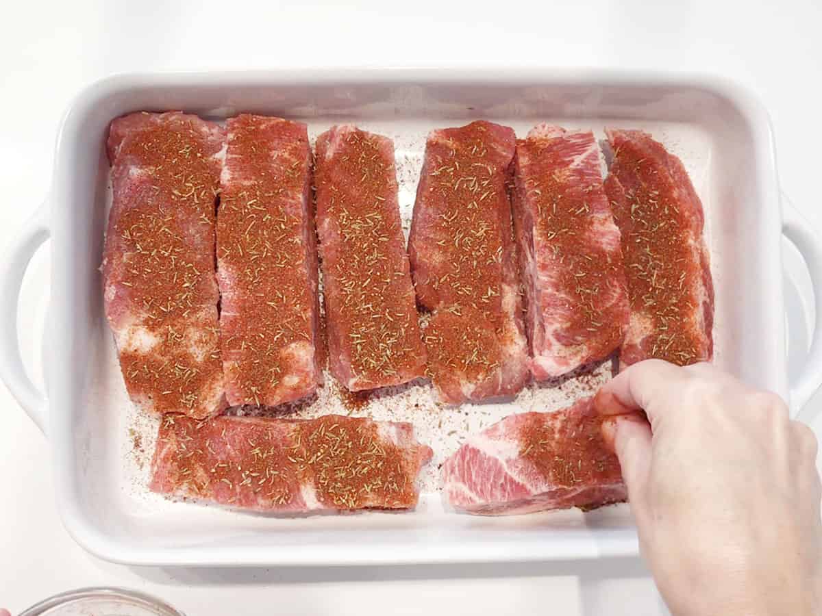 Sprinkling the ribs with spices.