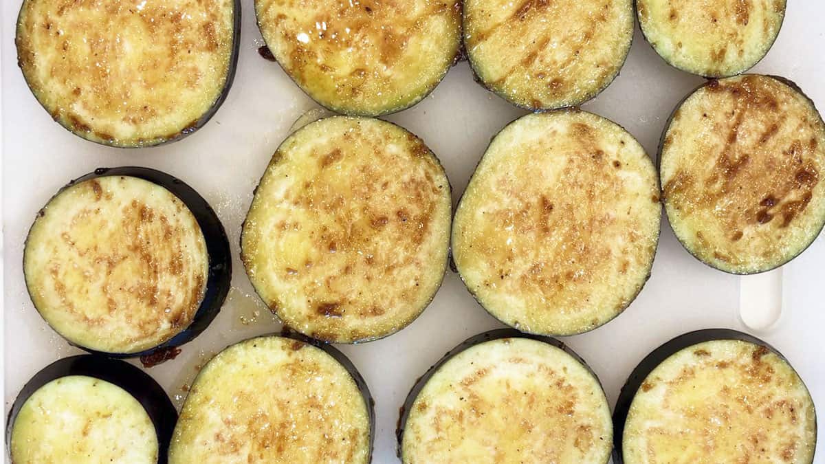 Raw eggplant slices coated in marinade.