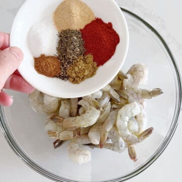 Adding spices to the shrimp.