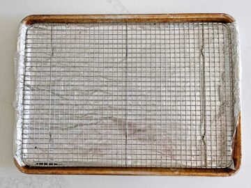 A rack fitted inside a rimmed baking sheet.