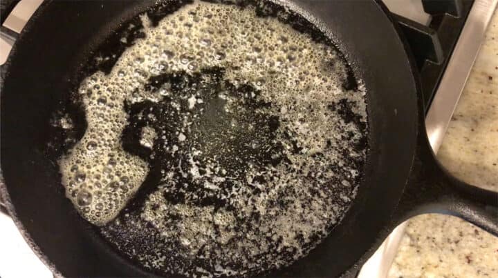 Heating coconut oil in a skillet.