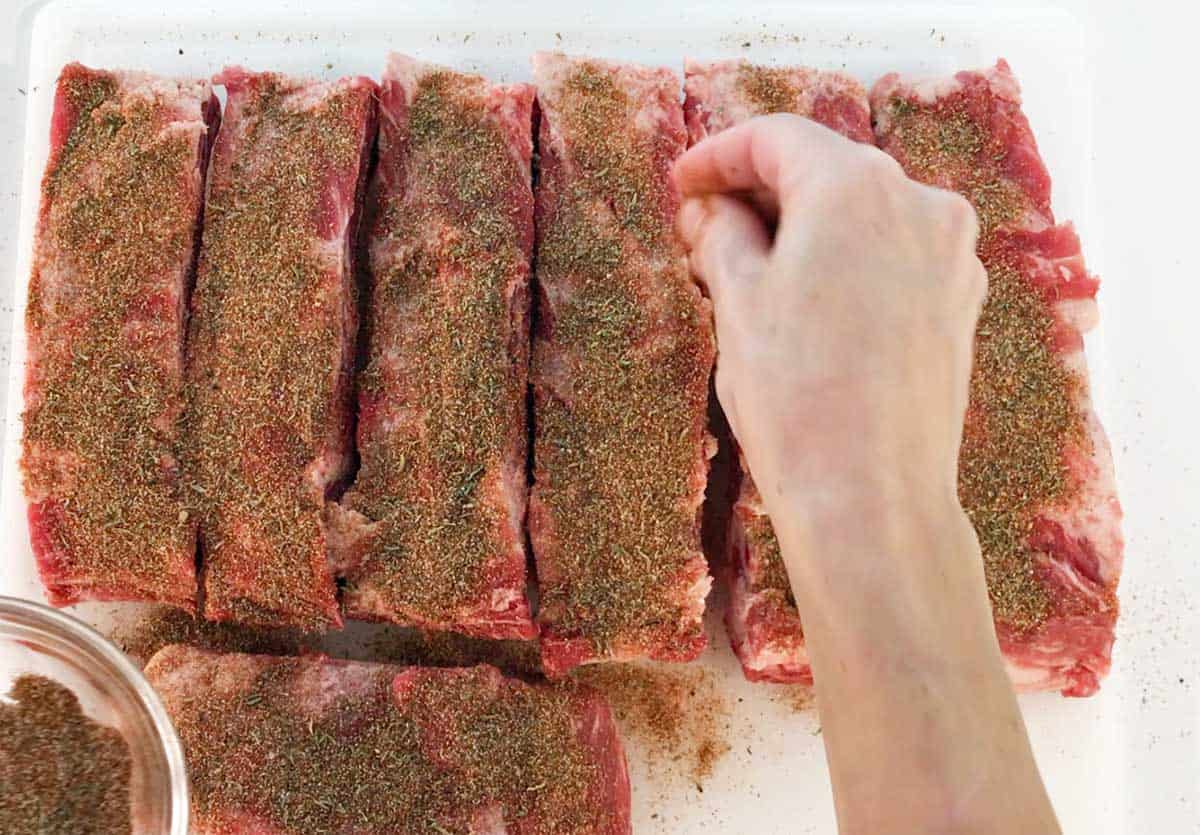 Seasoning the beef ribs.