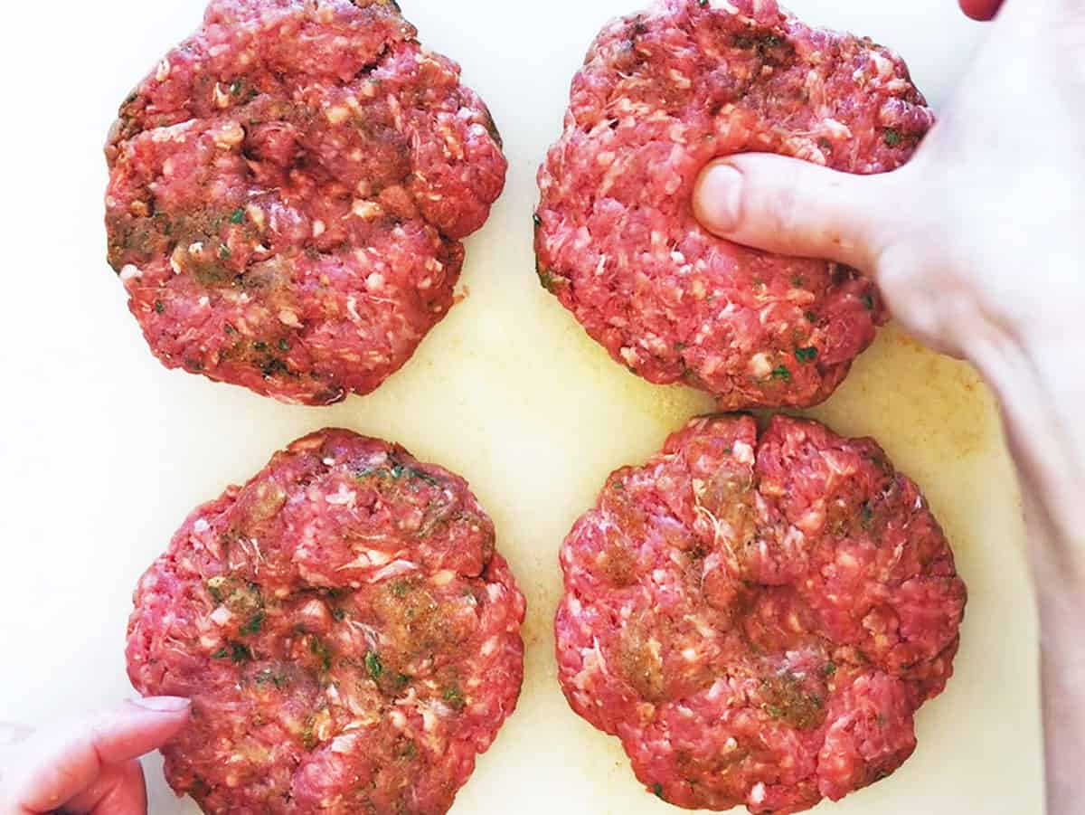Making a dimple in the burger patties.