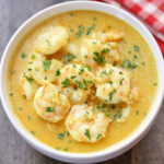 Shrimp curry is served in a white bowl.