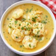 Shrimp curry is served in a white bowl.