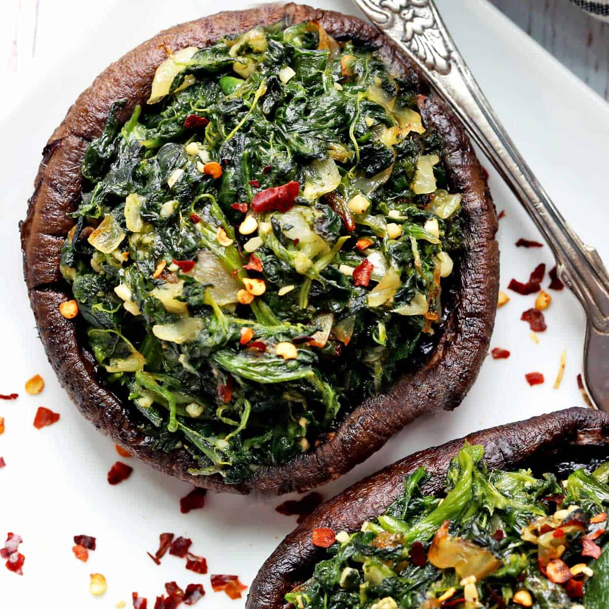 Stuffed portobello mushrooms garnished with red pepper flakes.