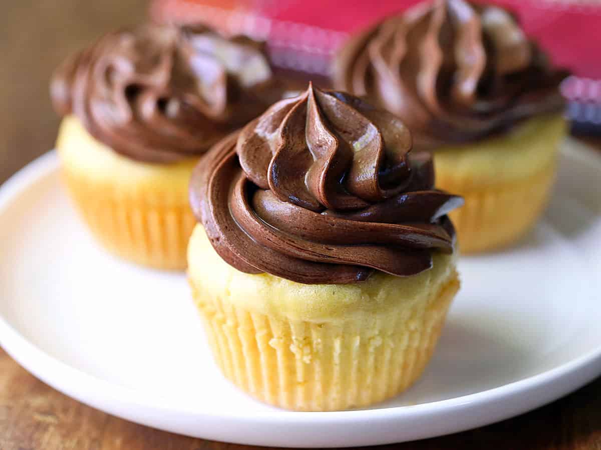Three keto cupcakes are served on a white plate.