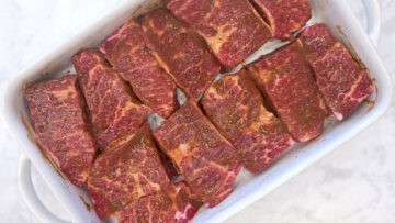 The boneless short ribs are arranged in a baking dish.