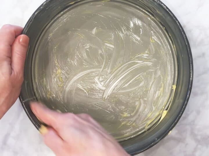 Buttering the pan.