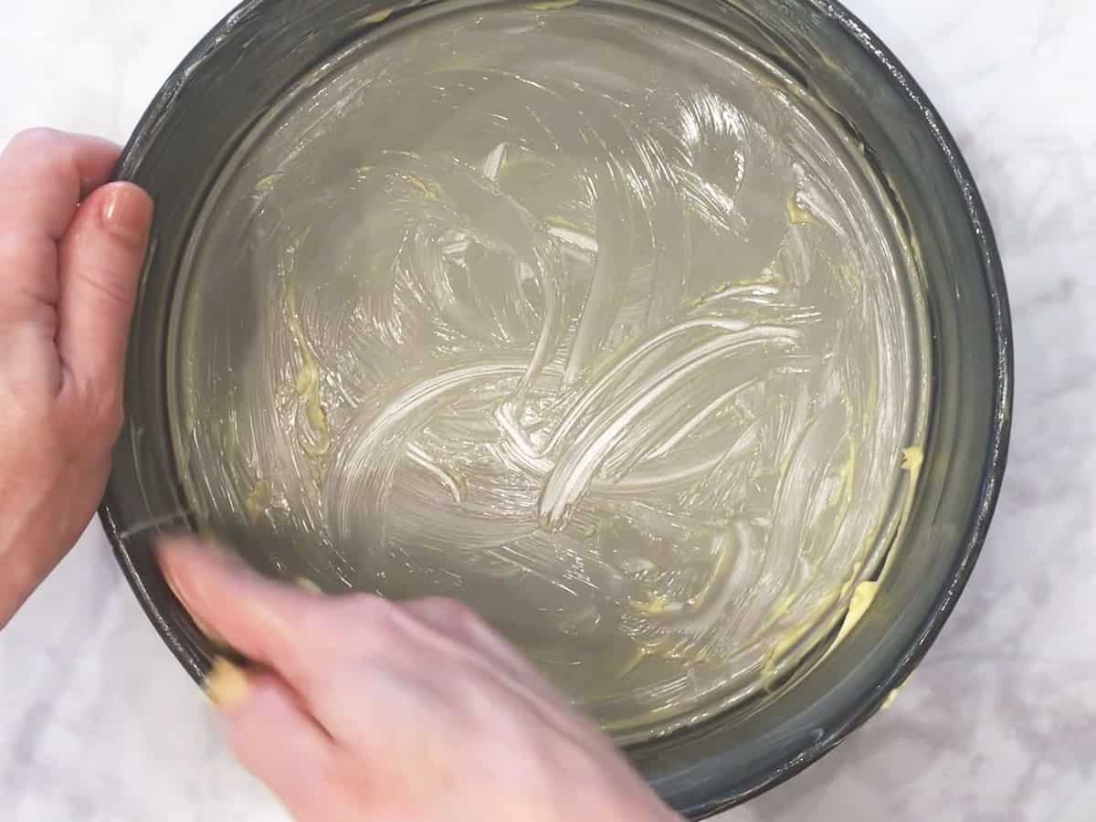 Buttering the pan.