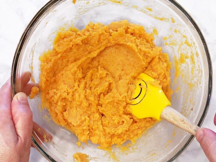 Mixing the mash with a rubber spatula.