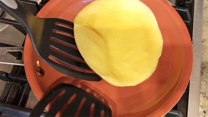 Flipping a crepe in the skillet.