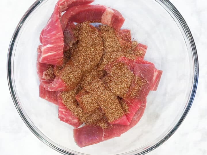 Seasoning the beef.