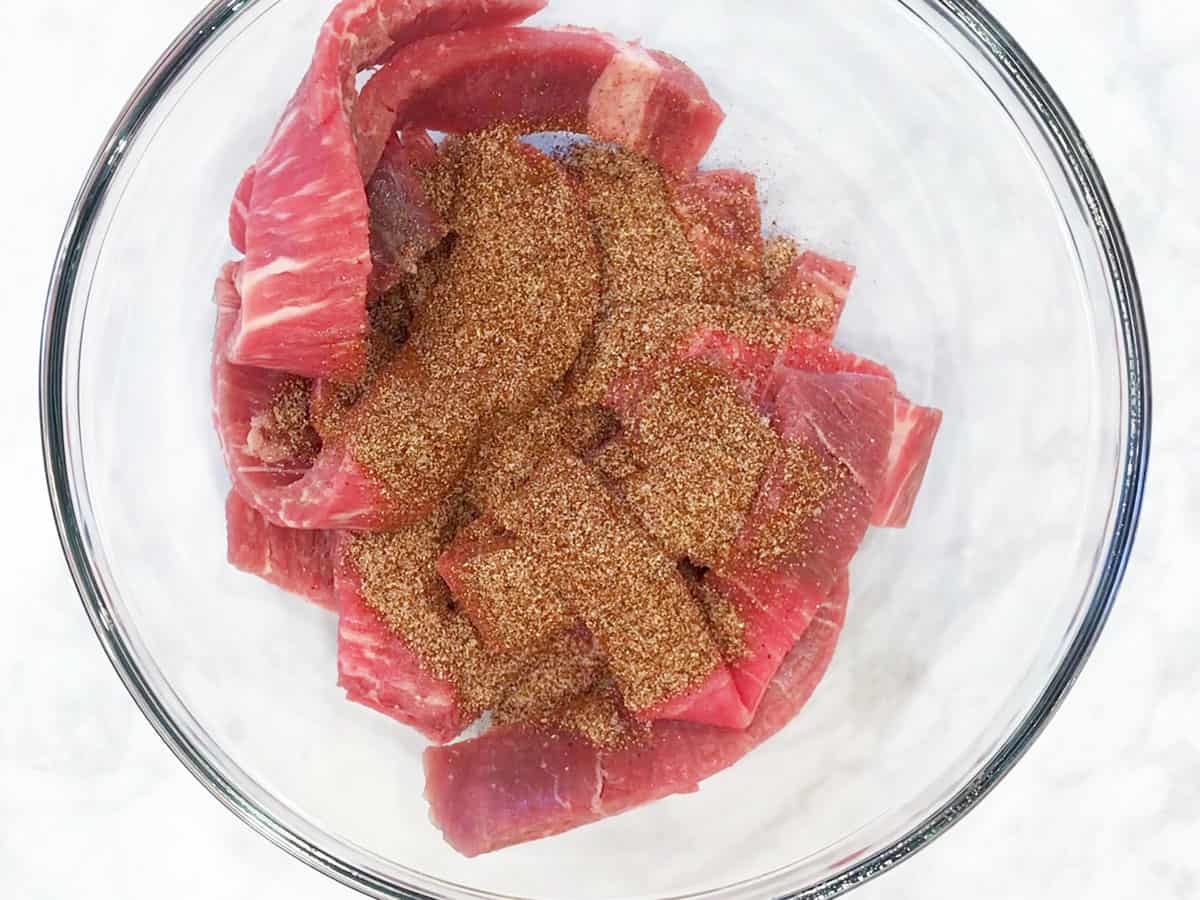 Seasoning the beef.