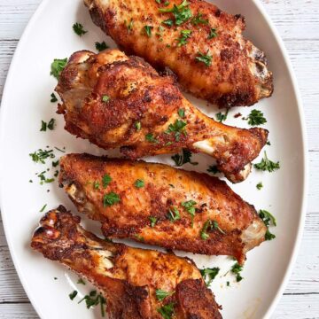 Baked turkey wings are served on a white platter.