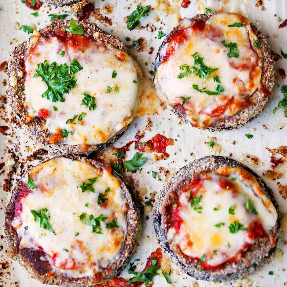 Keto eggplant parmesan on a parchment-lined baking sheet.