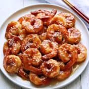 Sesame shrimp are served with chopsticks.