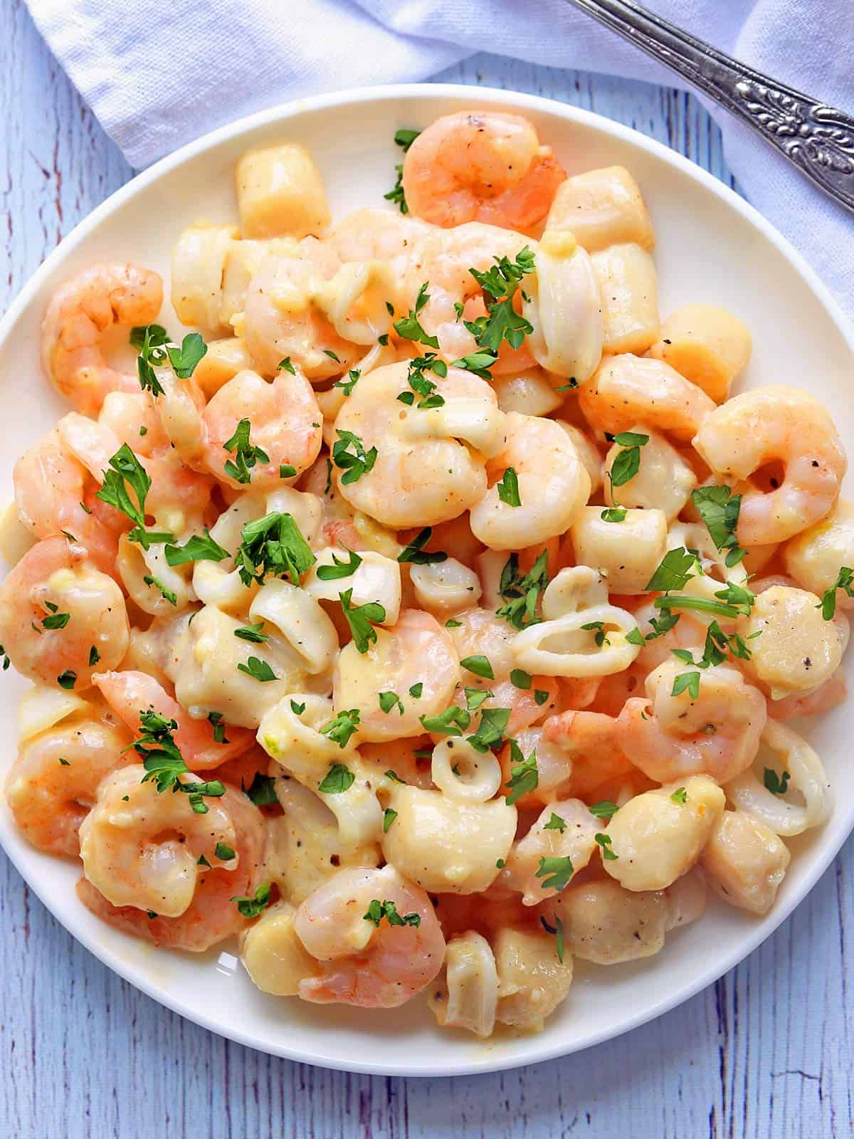 Seafood mix is served on a white plate.