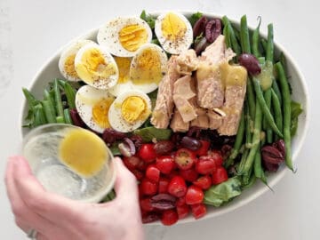Drizzling the salad with the remaining dressing.