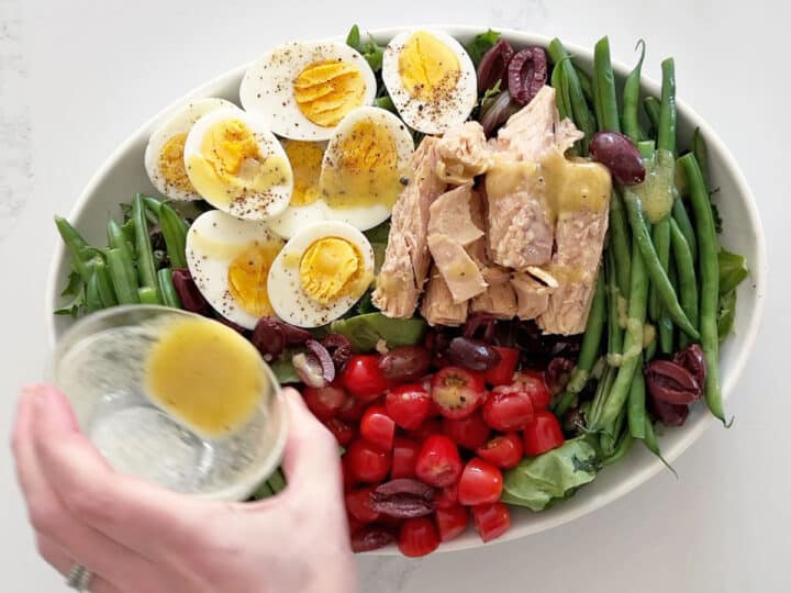 Drizzling the salad with the remaining dressing.
