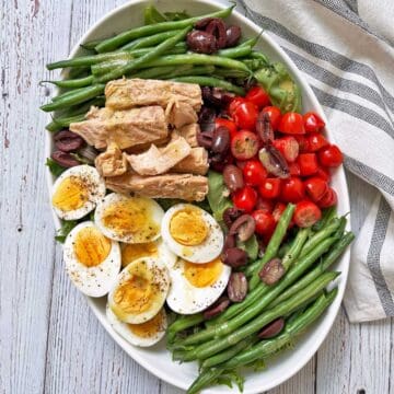 Nicoise salad is served on a platter with a napkin.