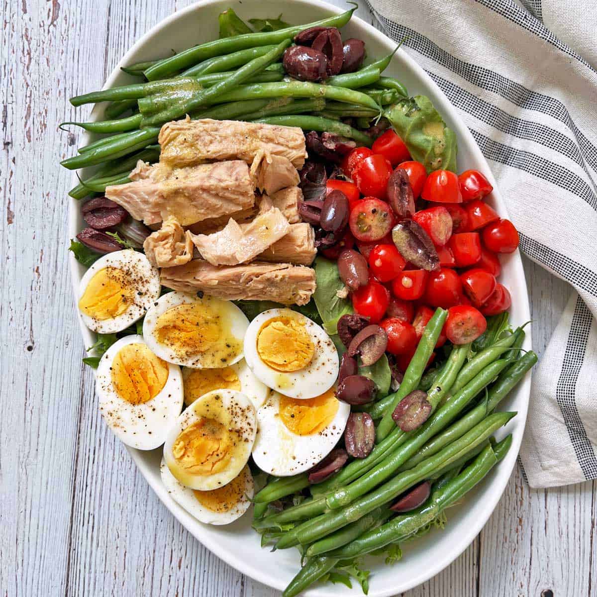 Nicoise salad is served on a platter with a napkin.