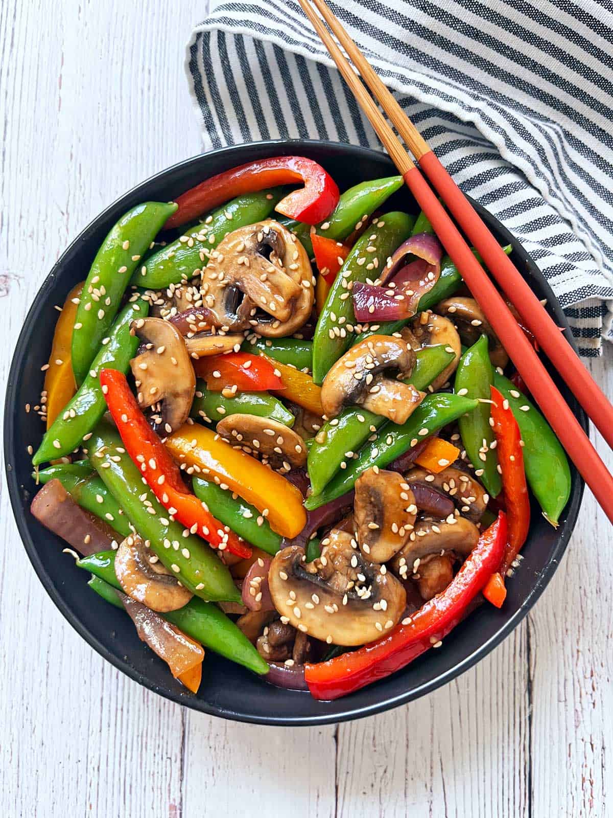 A vegetable stir-fry is served with chopsticks.