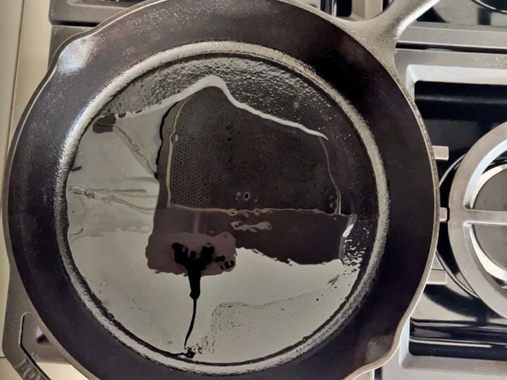 Heating oil in a cast-iron skillet.