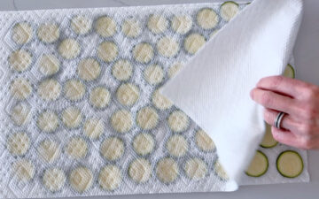 Blotting the zucchini dry.